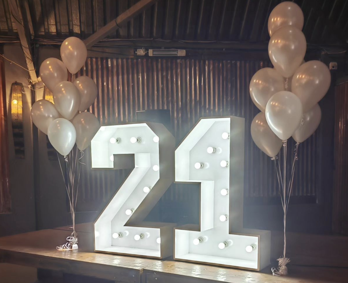 21st Marquee Numbers with white lights and our helium balloon bunches