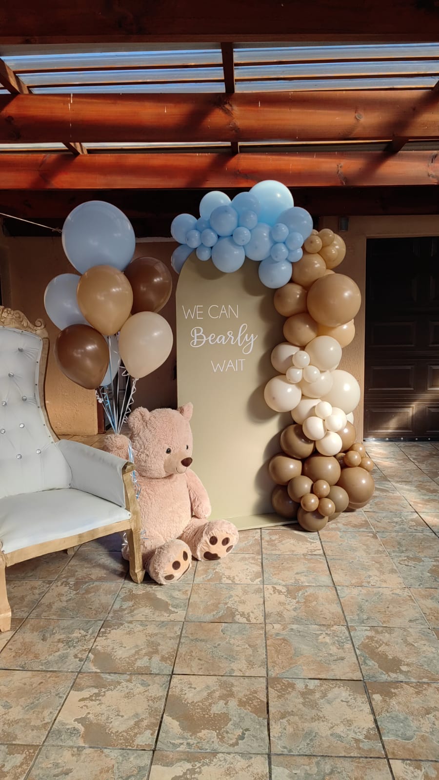 Personalised brown door arch with a balloon garland featuring our teddy bear